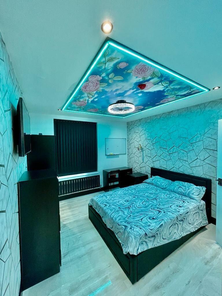 A stylish master bedroom featuring a unique ill...