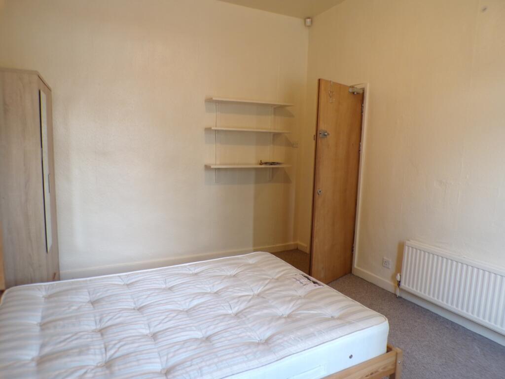 A spacious and tidy double bedroom with neutral...