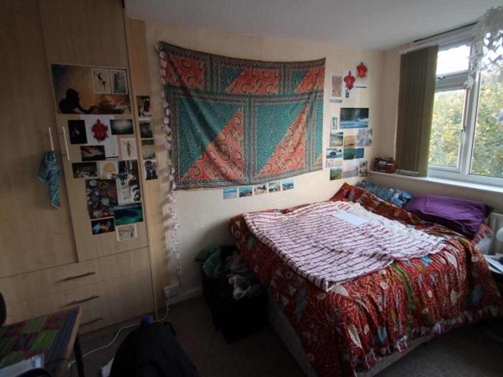 Cozy double bedroom with a large window offerin...