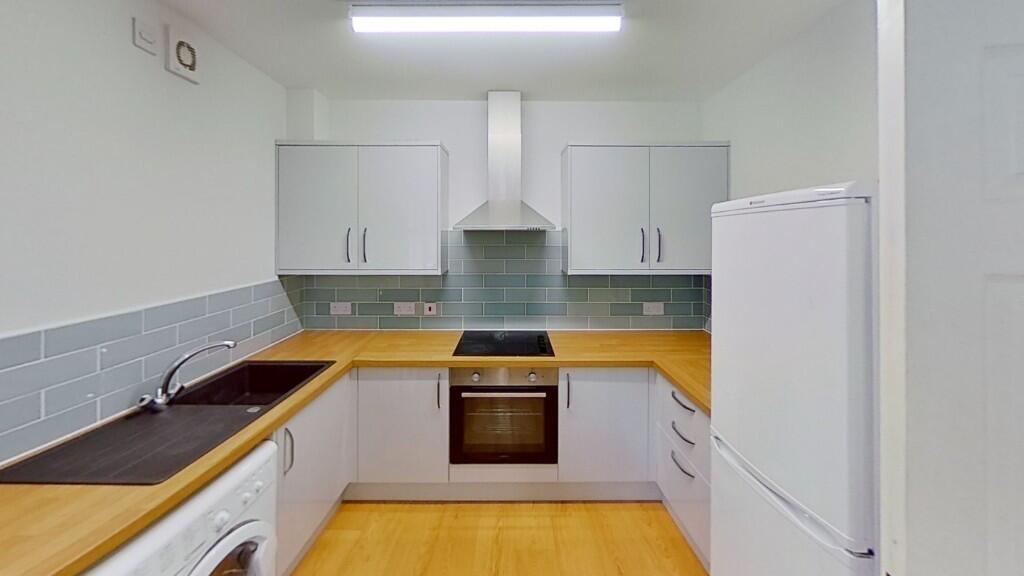 Bright and modern kitchen featuring clean white...