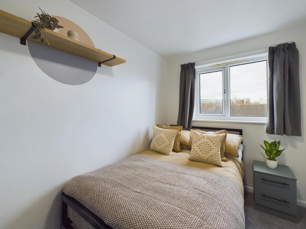 A bright and inviting double bedroom with moder...