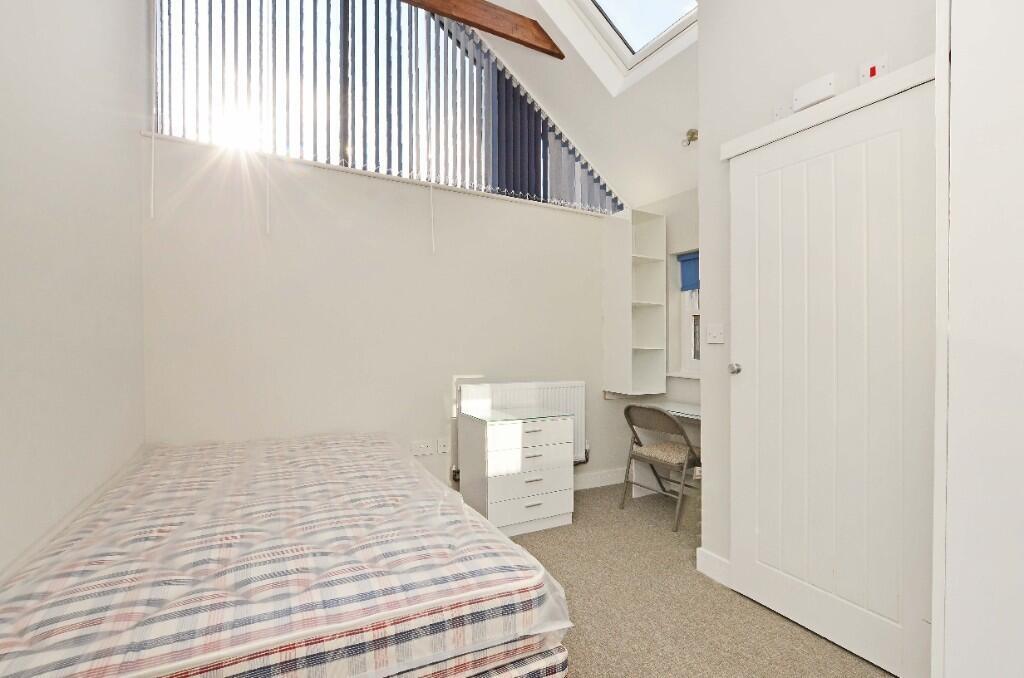 A bright and tidy single bedroom featuring a co...