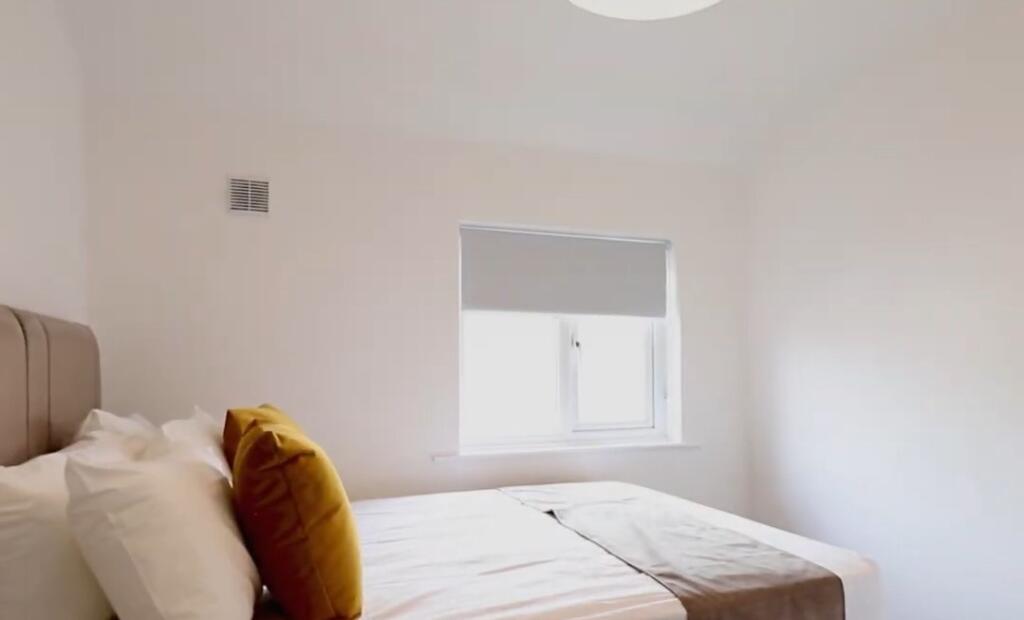 Bright and clean master bedroom featuring a com...