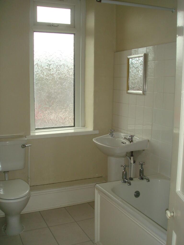 A functional bathroom with a small bathtub, a s...