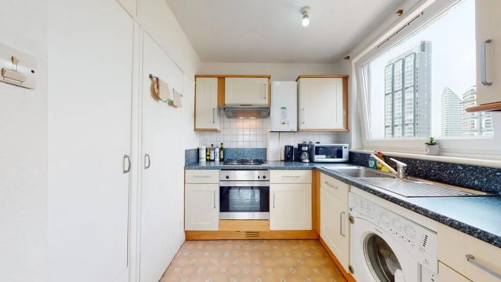A bright and modern kitchen featuring clean whi...