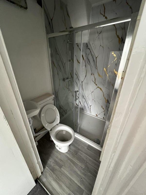A compact bathroom featuring a modern framed gl...