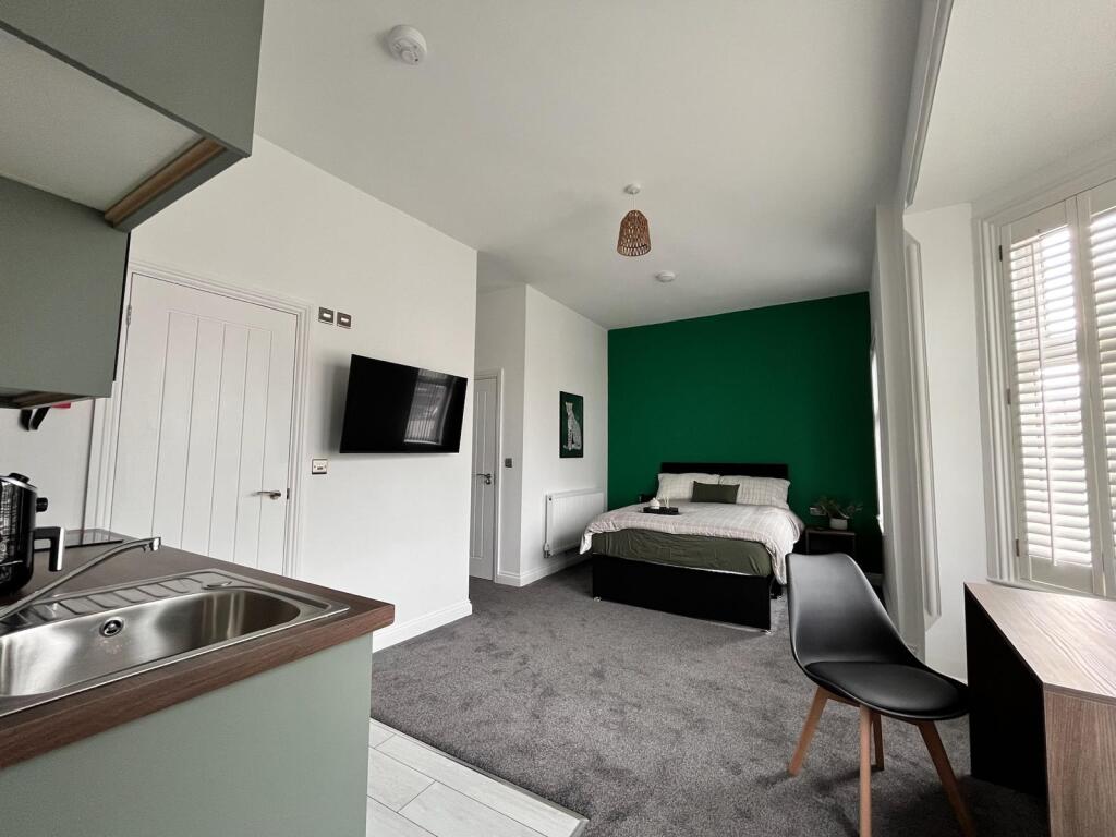 This inviting double bedroom features a cozy at...