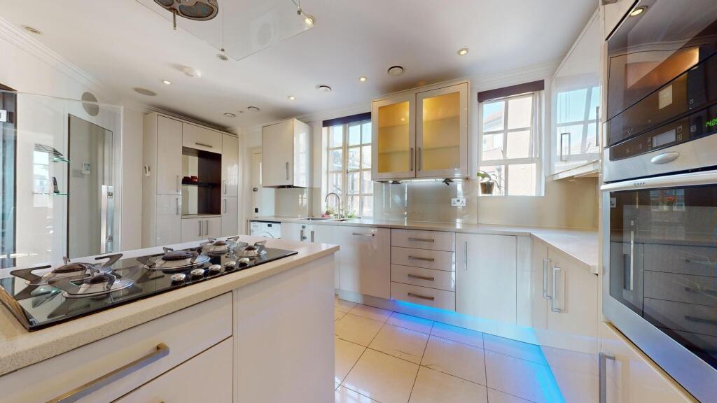A modern, bright kitchen featuring sleek white ...