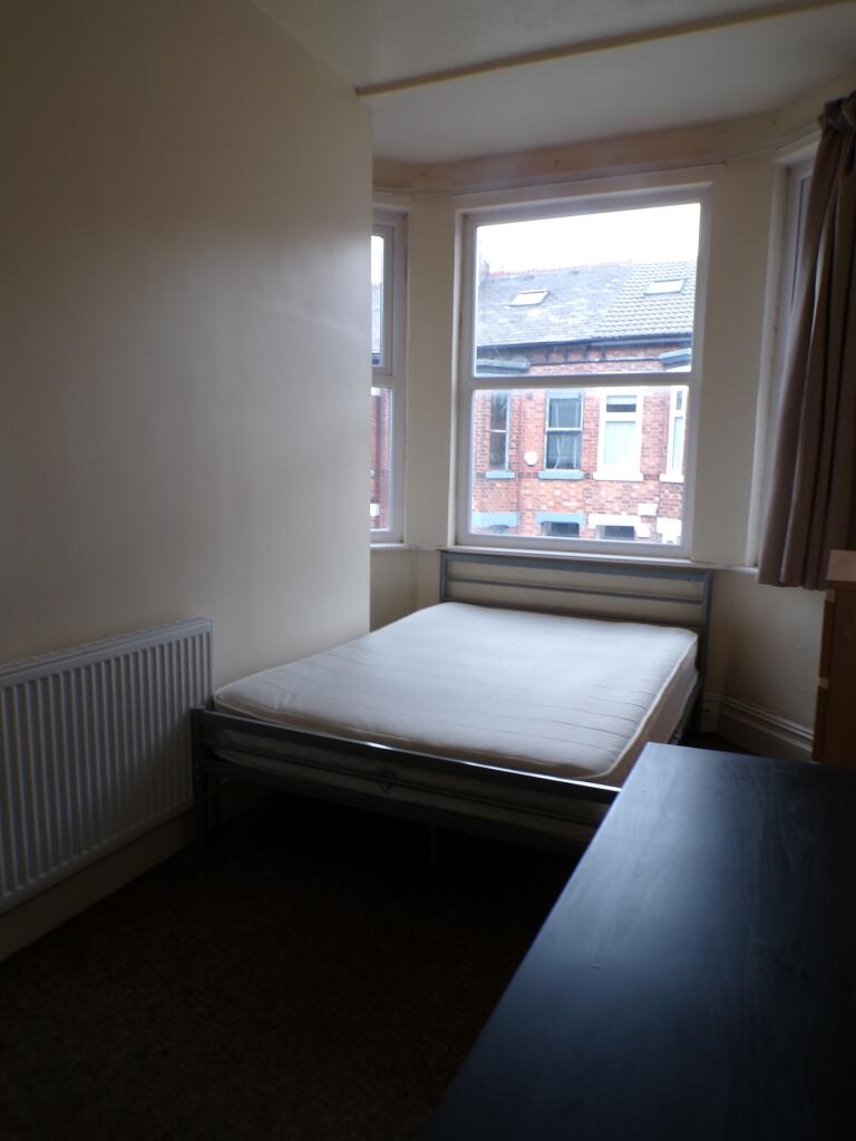 A bright and cozy double bedroom with large win...