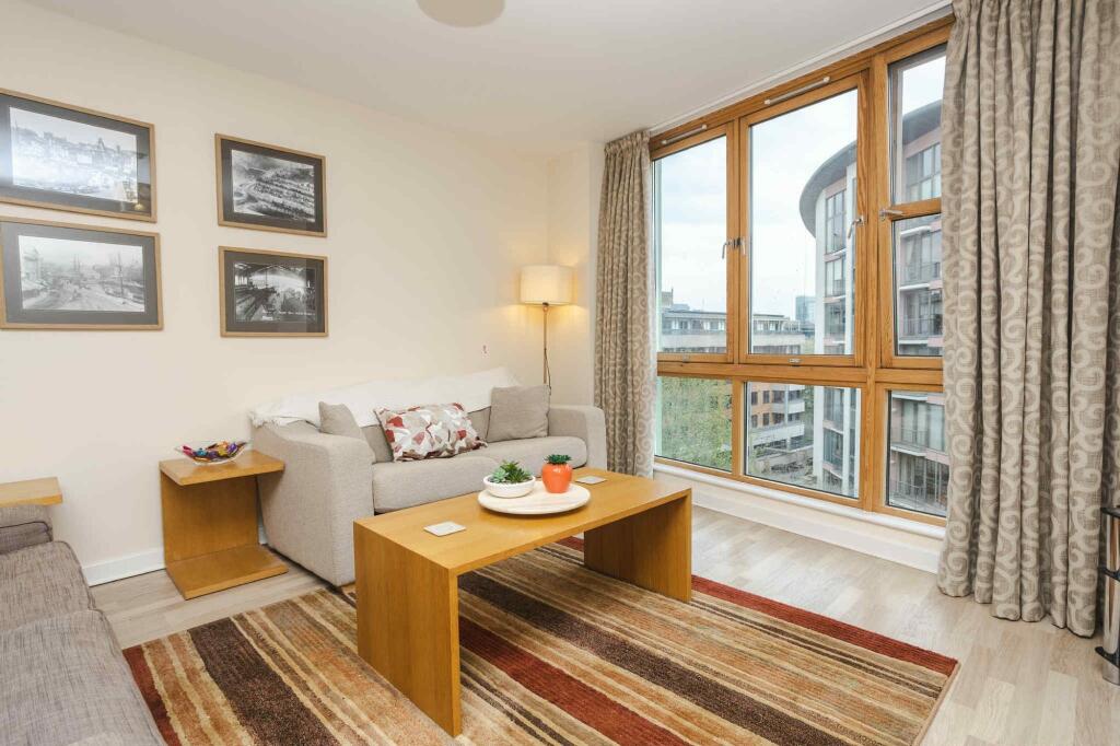 A bright and inviting living room featuring lar...