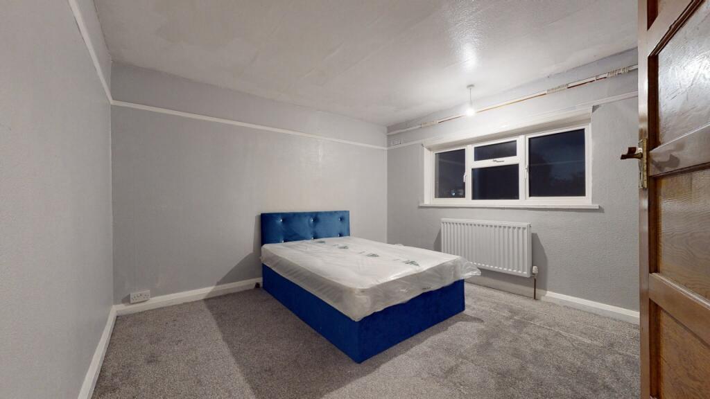 A spacious and well-lit master bedroom featurin...
