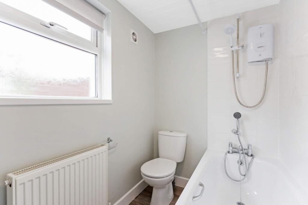 A bright and modern bathroom featuring a bath a...