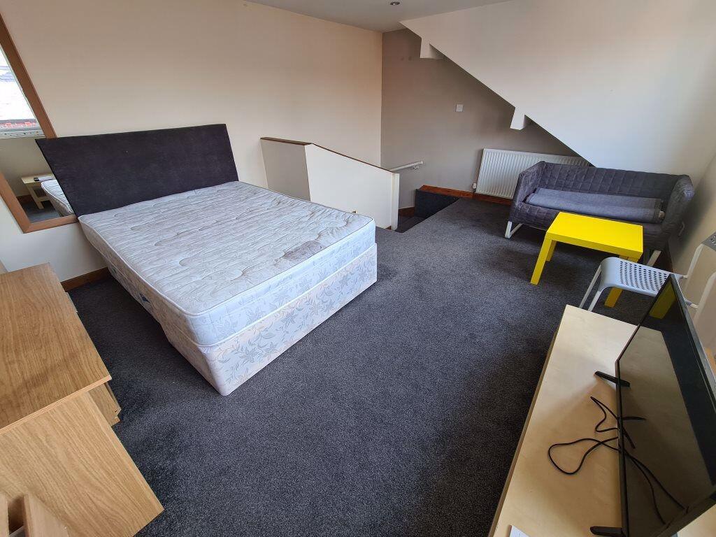 A spacious double bedroom featuring a large bed...