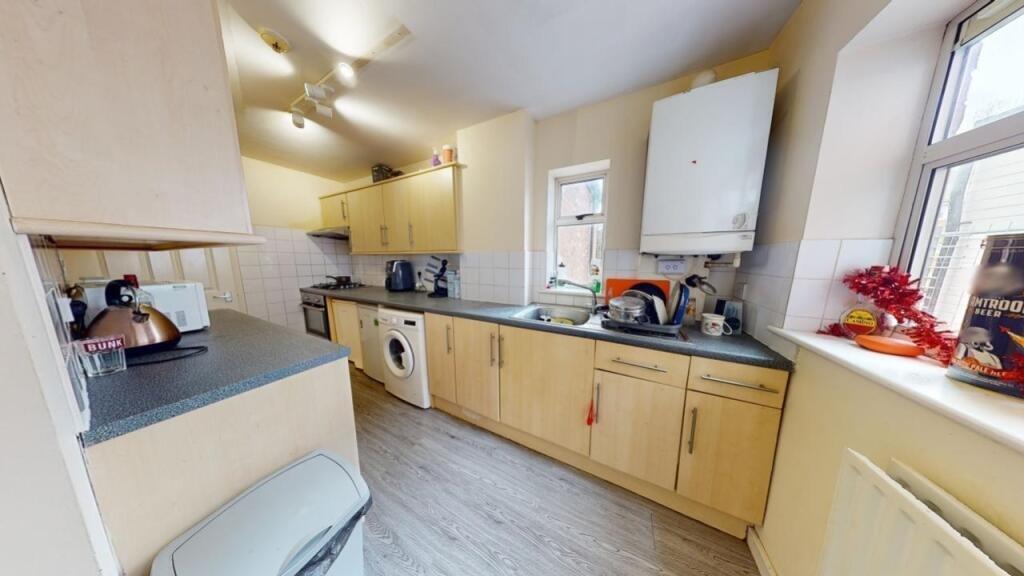 Bright and neatly arranged kitchen featuring li...