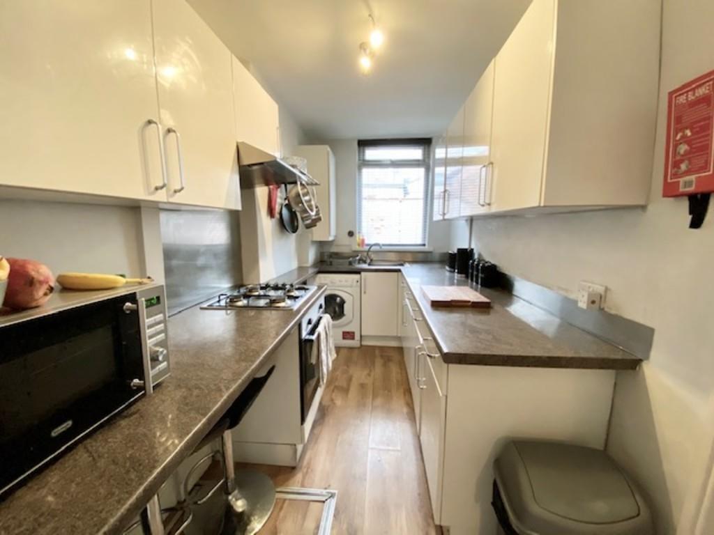 Bright and modern galley kitchen with ample cou...