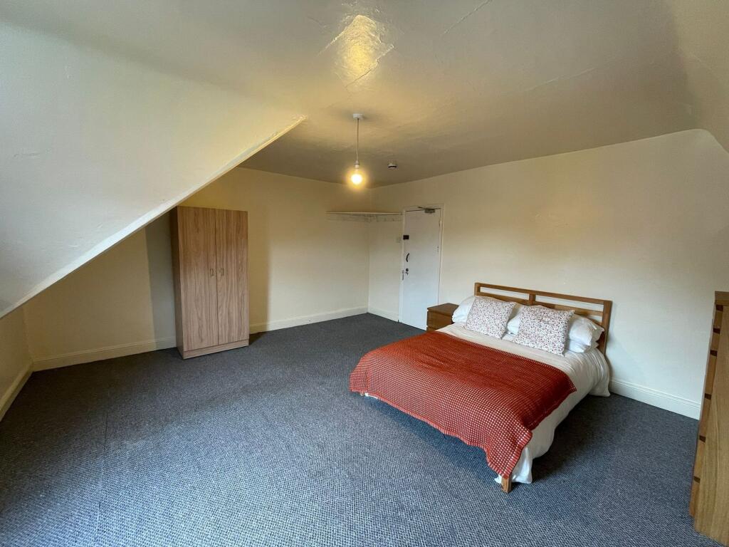 Spacious double bedroom featuring a comfortable...