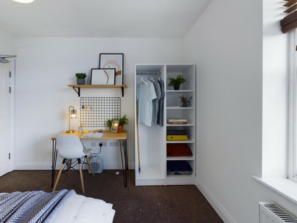 A bright and tidy double bedroom featuring a st...