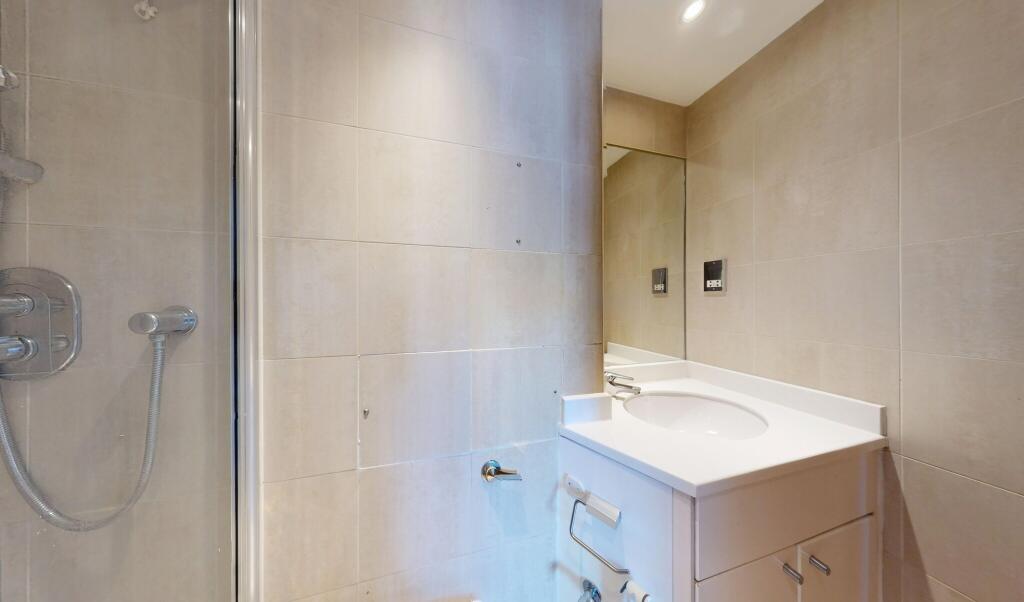 Modern bathroom featuring a walk-in shower with...