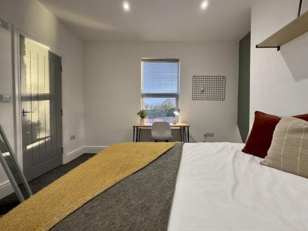 A bright and inviting double bedroom with a coz...