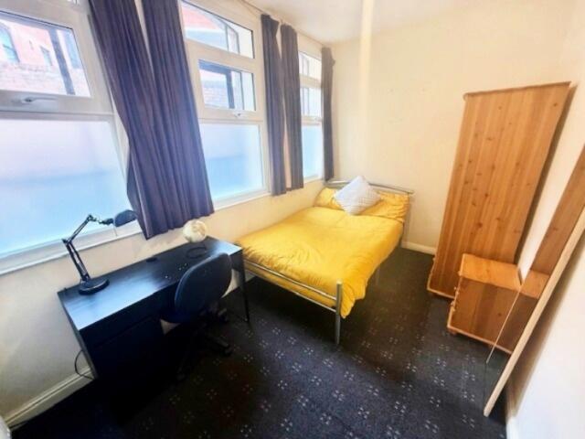 Bright and cozy single bedroom featuring a comf...