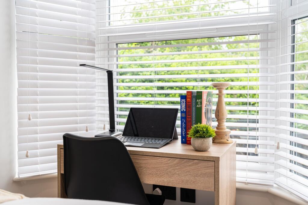 A bright and tidy workspace featuring a wooden ...