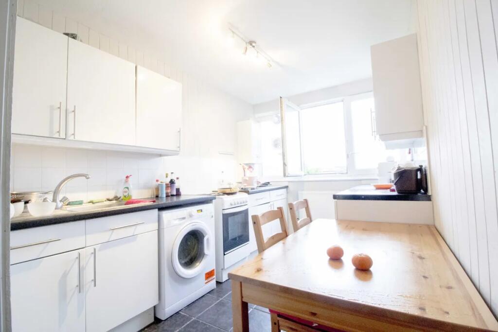 Bright and tidy kitchen featuring modern white ...