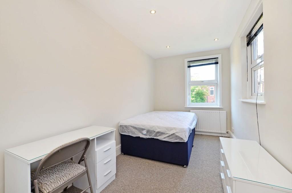 A neat and well-lit single bedroom featuring a ...