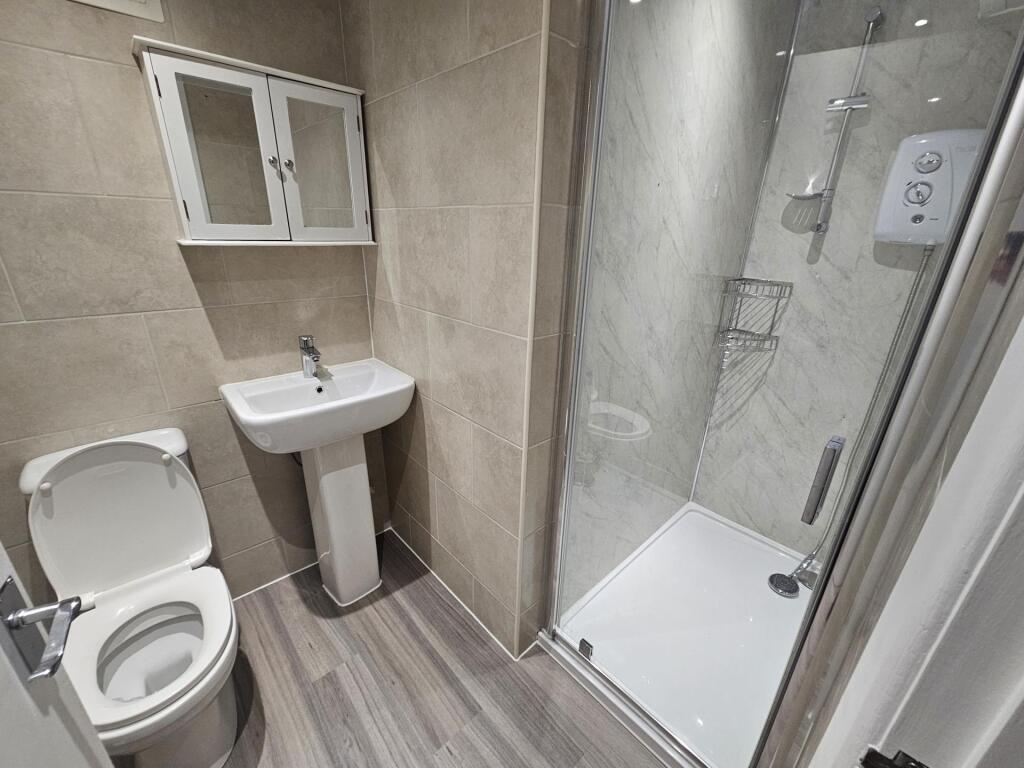 A modern, tidy bathroom with a large shower enc...