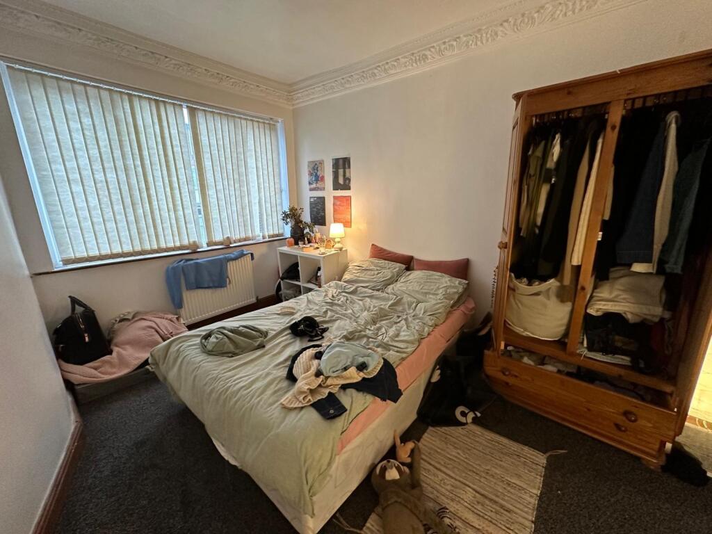 A cozy bedroom with a large window providing na...