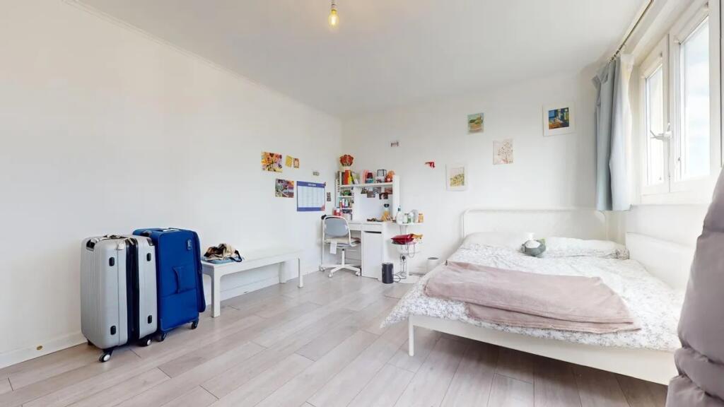 A bright, tidy double bedroom featuring a white...