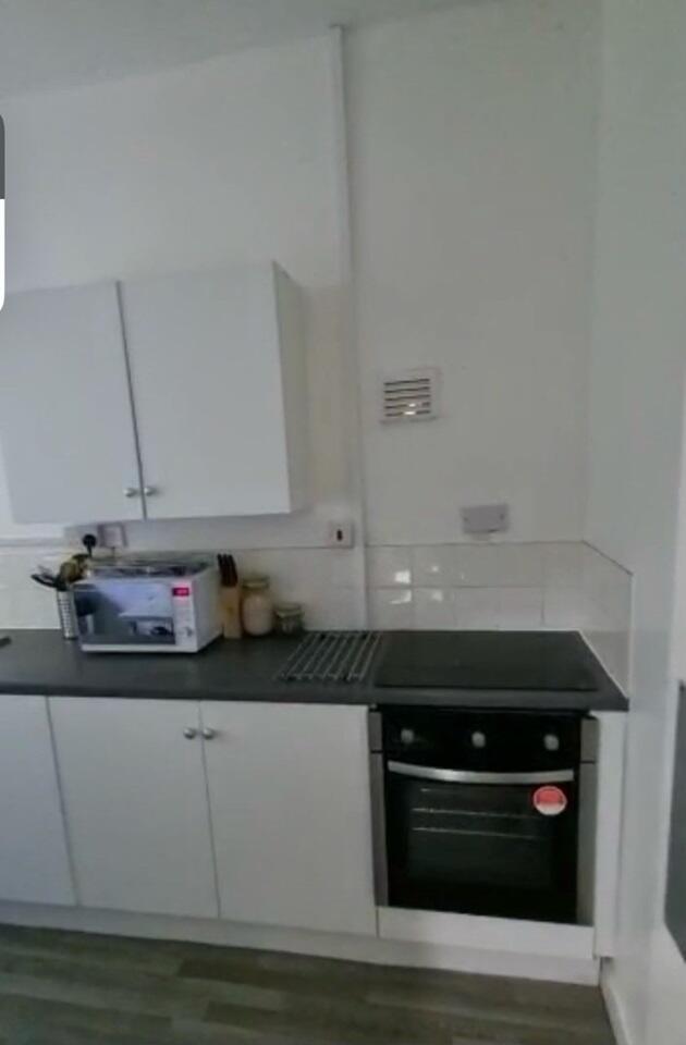 A neat and functional kitchen featuring white c...