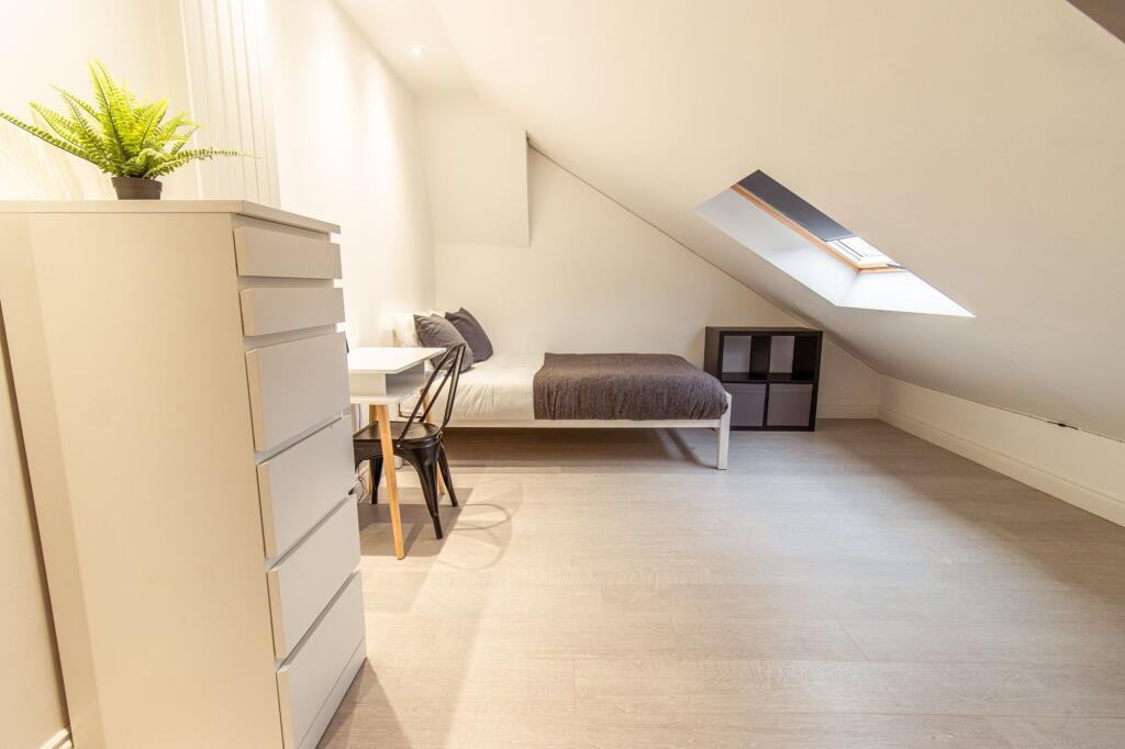 Bright, modern attic bedroom with a comfortable...