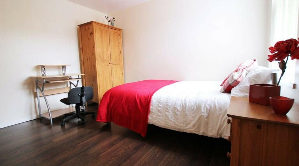 A cozy student bedroom featuring a single bed w...