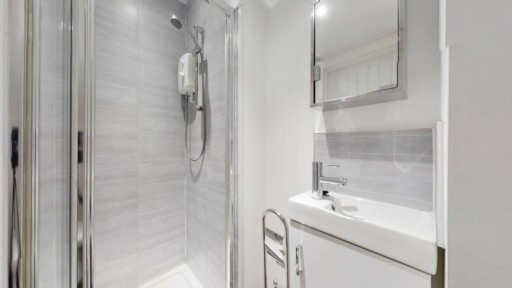 A modern bathroom suite featuring a sleek walk-...