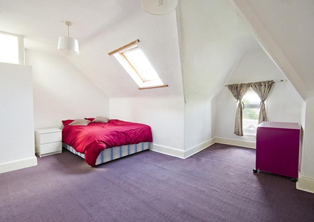 A spacious and inviting double bedroom with amp...