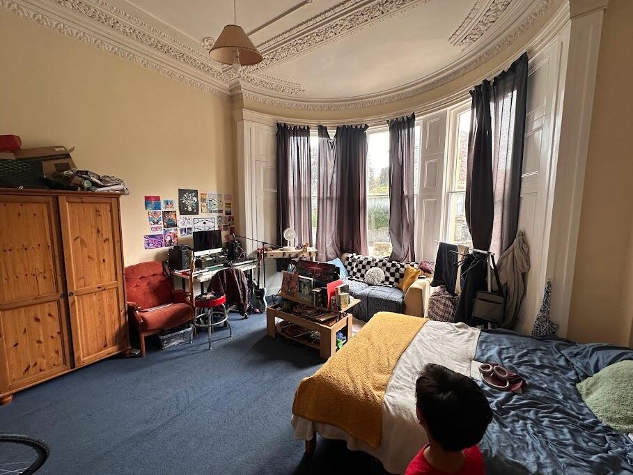 Spacious master bedroom with a charming bay win...