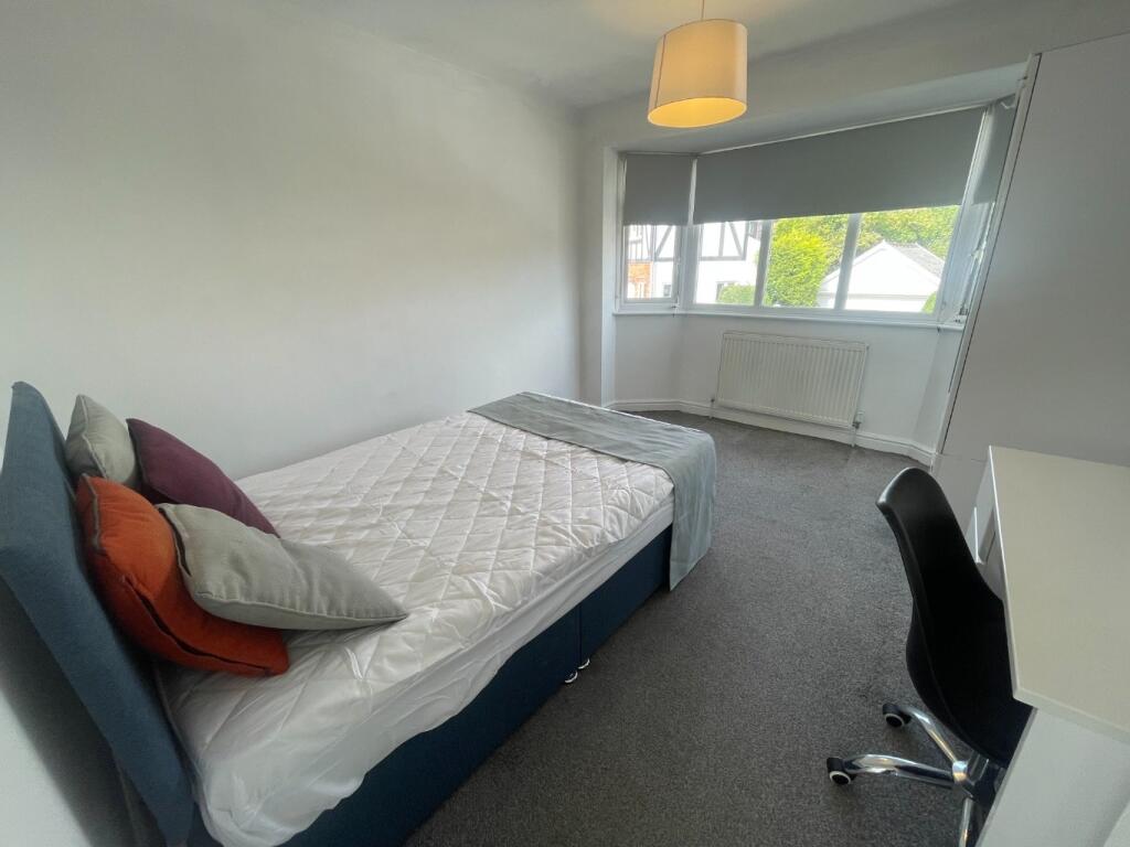 This inviting double bedroom features a comfort...