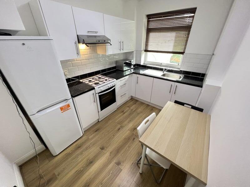 Bright and modern kitchen featuring clean white...