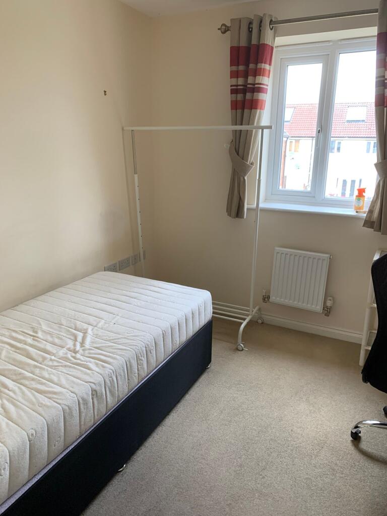 A bright single bedroom featuring a comfortable...