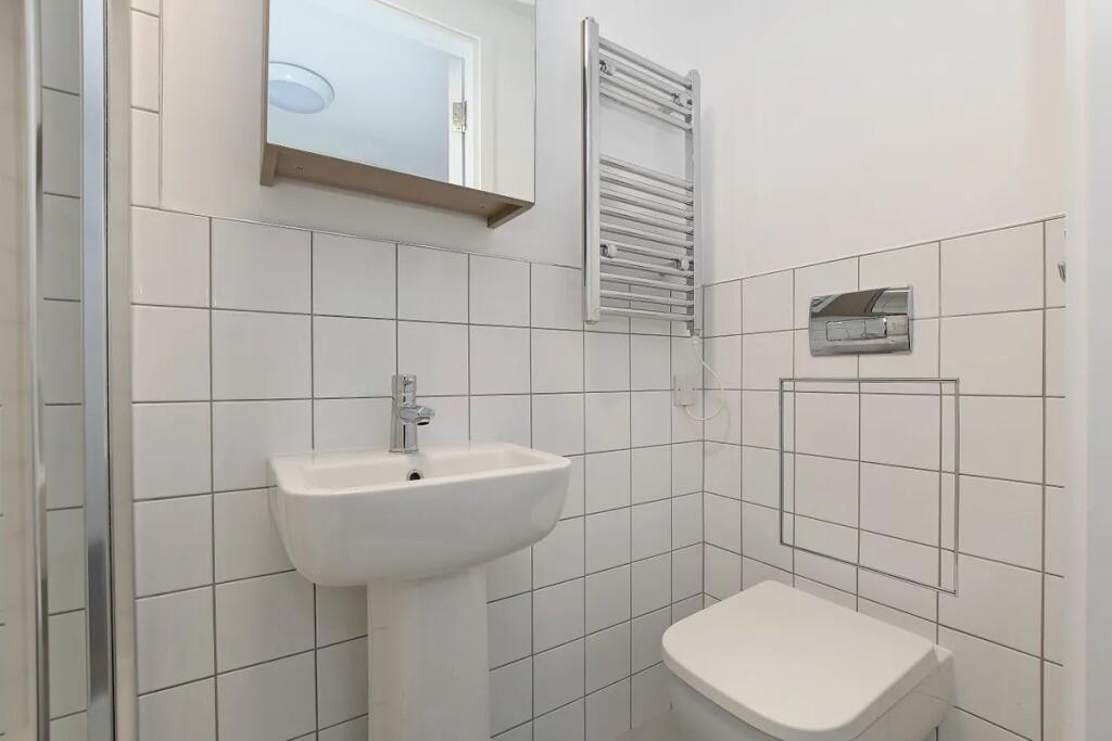 Modern bathroom featuring a clean white pedesta...