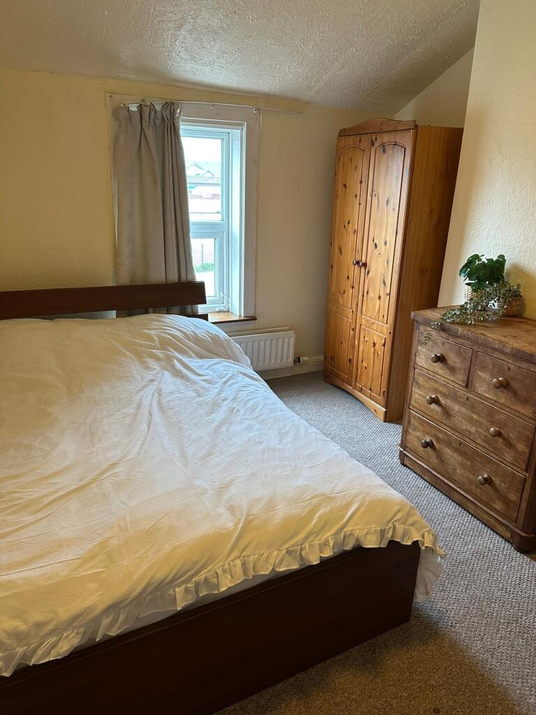 A cozy double bedroom featuring a large bed, wo...