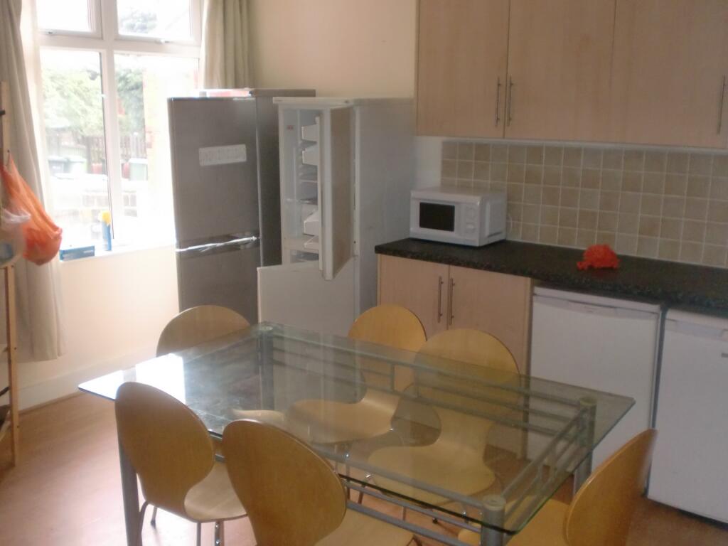 Bright kitchen with a glass dining table and si...