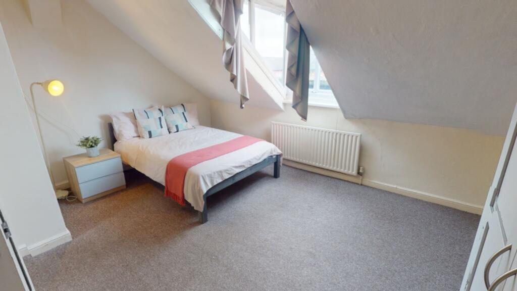 A cozy and well-lit double bedroom with modern ...