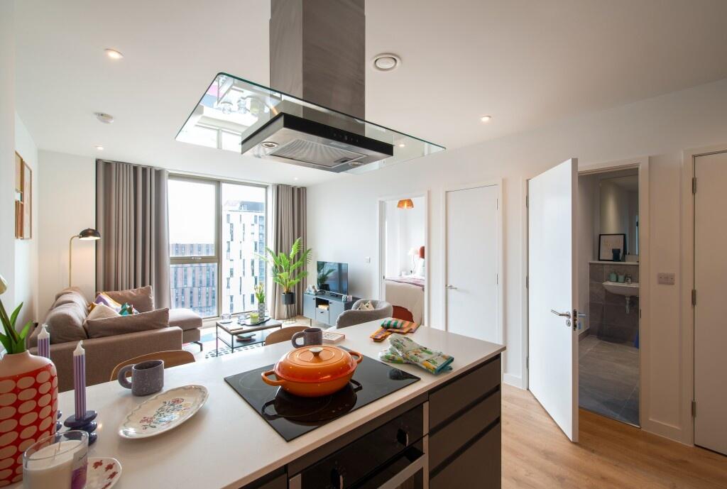 A modern, well-lit living room with a cozy sofa...