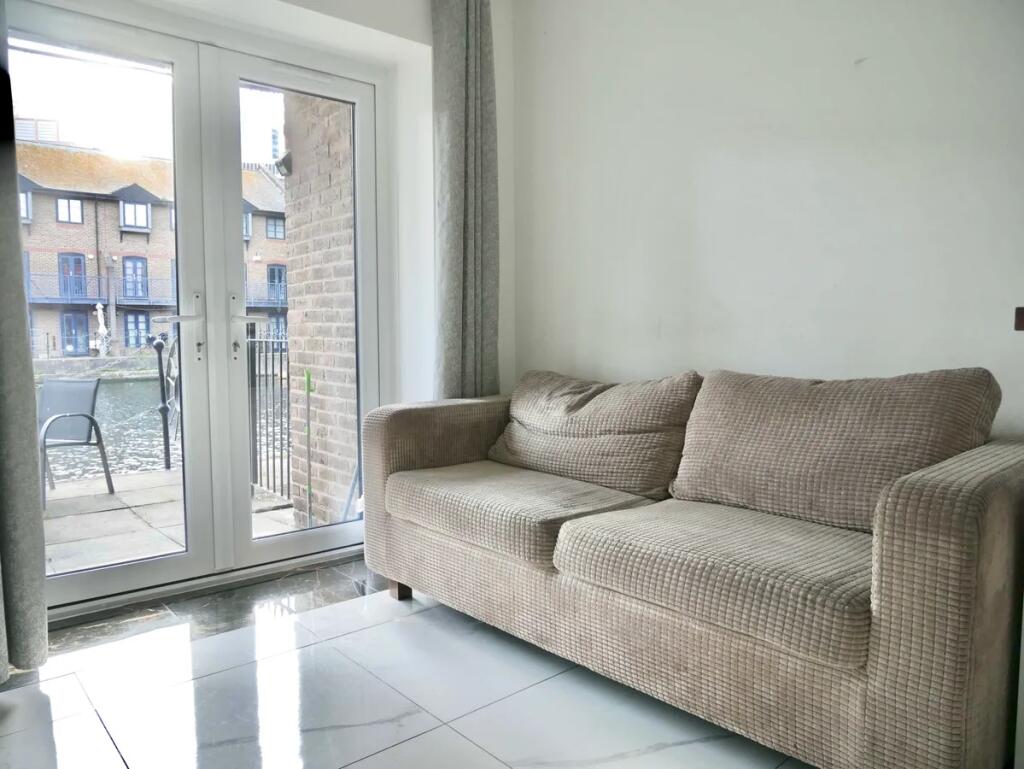 A bright and tidy living room featuring a comfo...