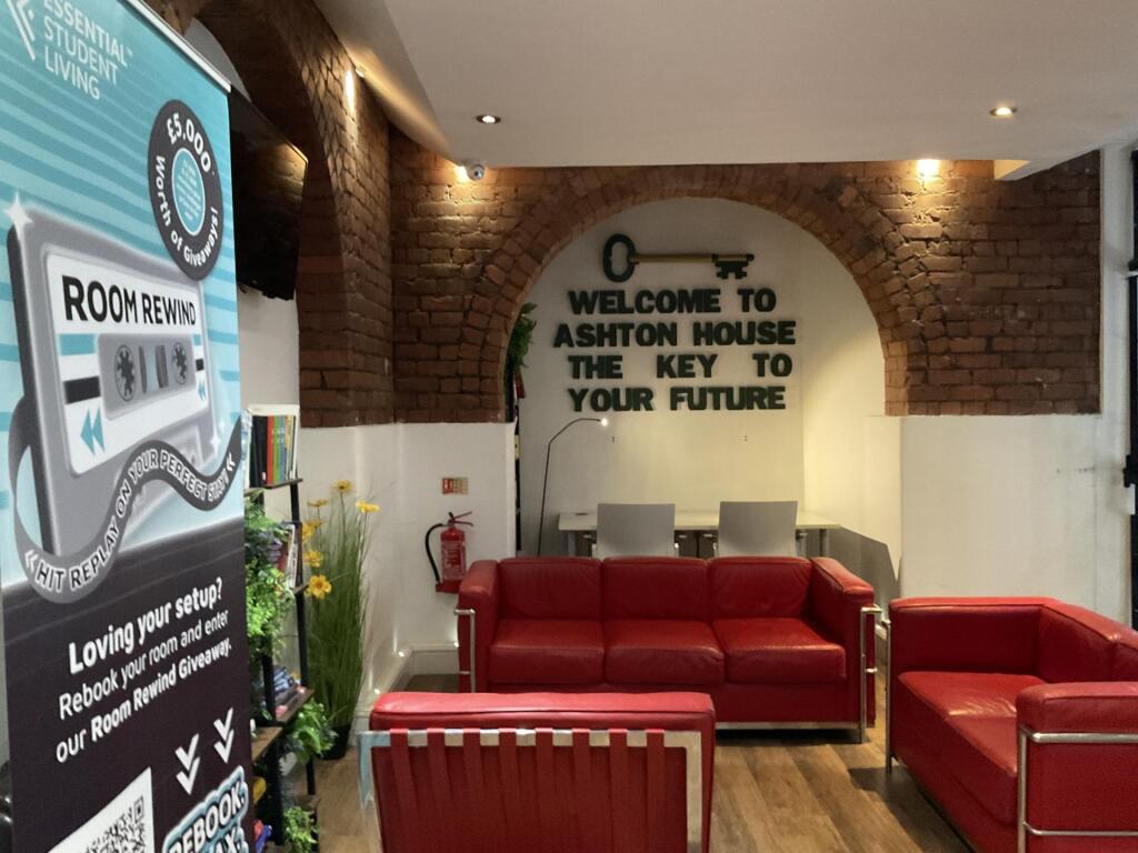 A cozy communal lounge with exposed brick walls...
