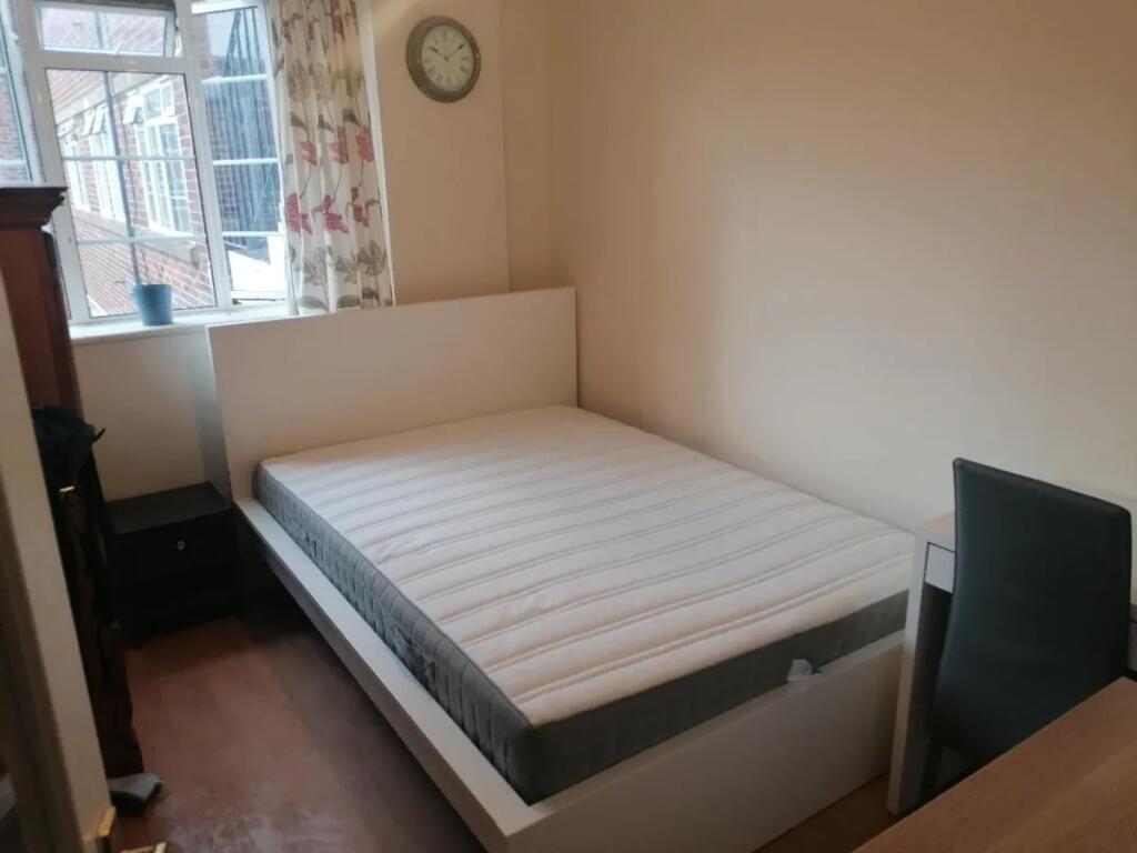 A neat double bedroom featuring a comfortable b...