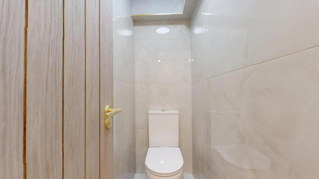 A clean and modern single toilet with light bei...