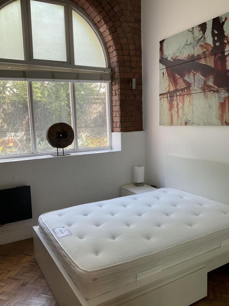 Bright and airy master bedroom featuring a larg...