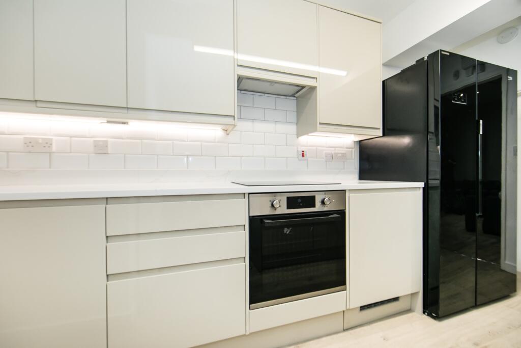 A modern, clean kitchen featuring sleek white c...